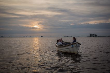 Sloep vaart met zonsondergang in de avond