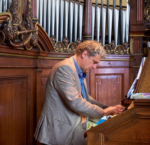 man spelend op orgel in kerk