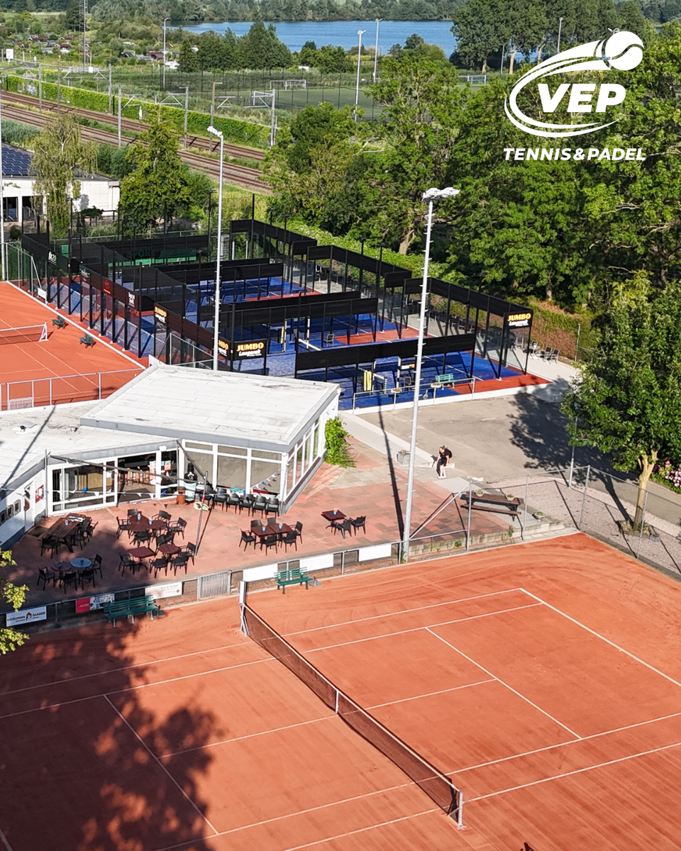 Tennis- en padelpark VEP Tennis & Padel, met graveltennisbanen, blauwe padelbanen, clubhuis en terras in een groene omgeving aan het water.