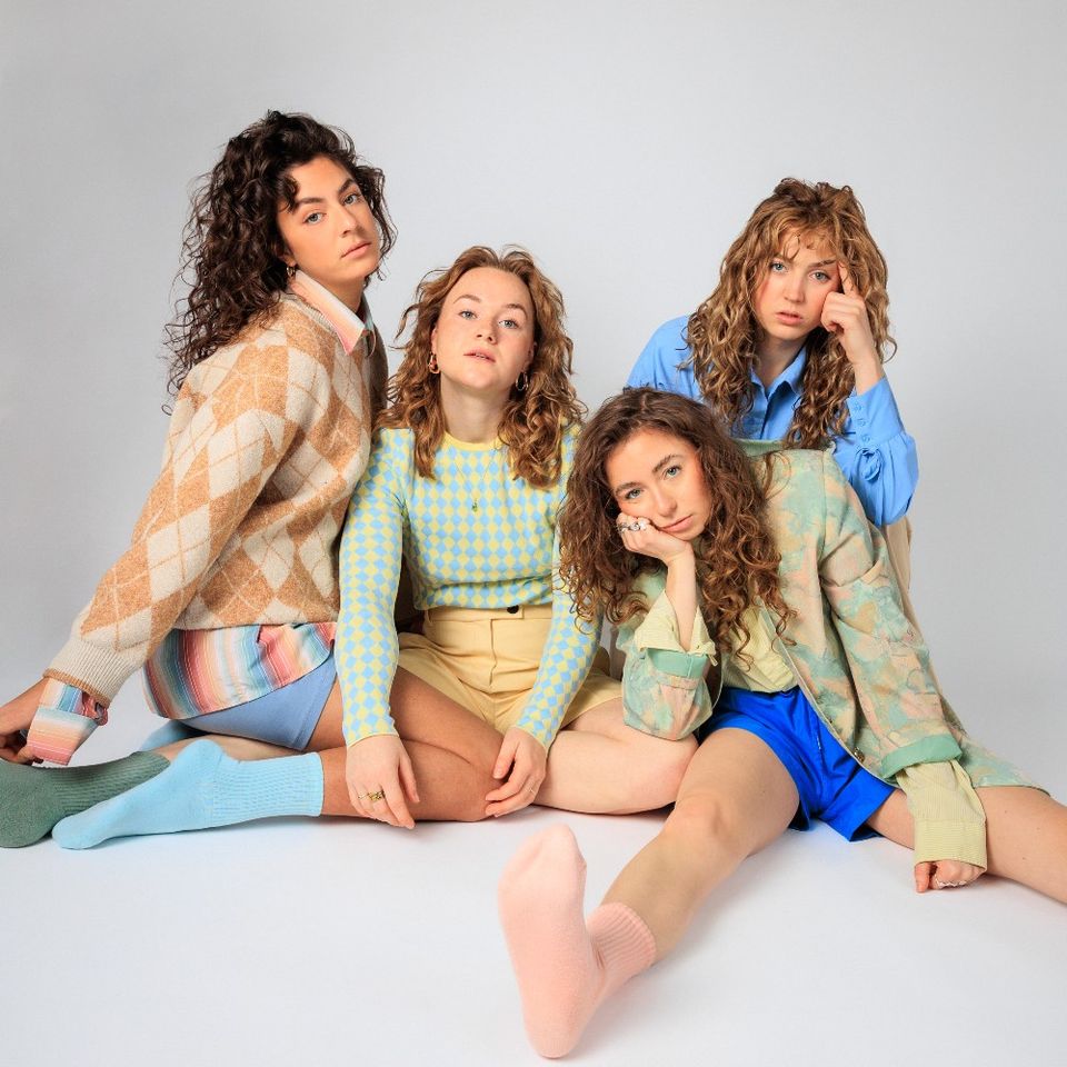 De vier jonge vrouwelijke leden van de Meute zittend op de grond.