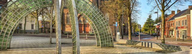 kunstwerk van kruislings gebogen staal en groen glas