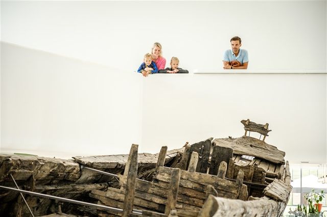 Bezoekers bewonderen het originele schip De Meern 1 in Castellum Hoge Woerd.