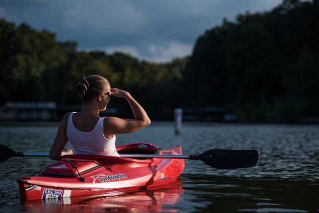Een vrouw die heerlijk aan het kanoën is op het water.
