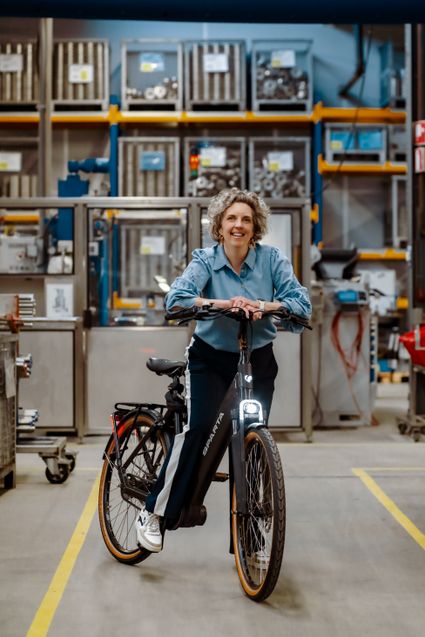 Persoon die op een fiets zit in een fabriek