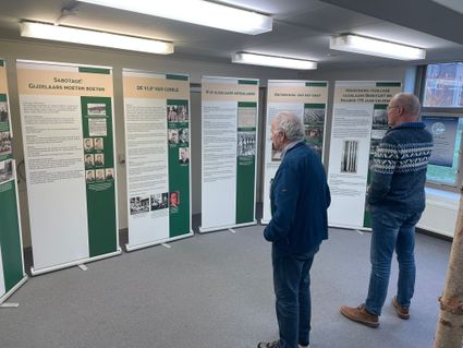Mensen bekijken tentoonstelling in het voormalig Gijzelaarskamp Beekvliet in Sint-Michielsgestel