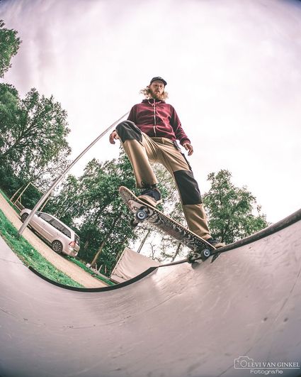 Jongen die skateboard op skatebaan