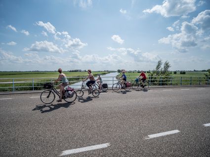 een groepje mensen fiets over de weg