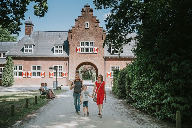 Gezin loopt onder het poortgebouw van Huis Doorn door