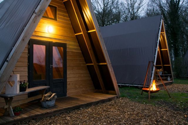 Twee outdoor tenten met een kampvuurtje in het midden.