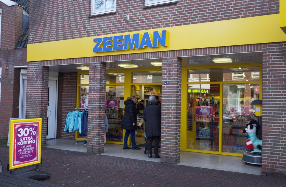 Stenen gevel met etalage en gele balk met blauwe letters Zeeman.