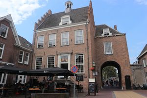 Het Oude Stadhuis in Montfoort, een monumentaal bakstenen gebouw uit de Middeleeuwen met trapgevel, stadscafé-terras en de historische IJsselpoort aan de rechterzijde.