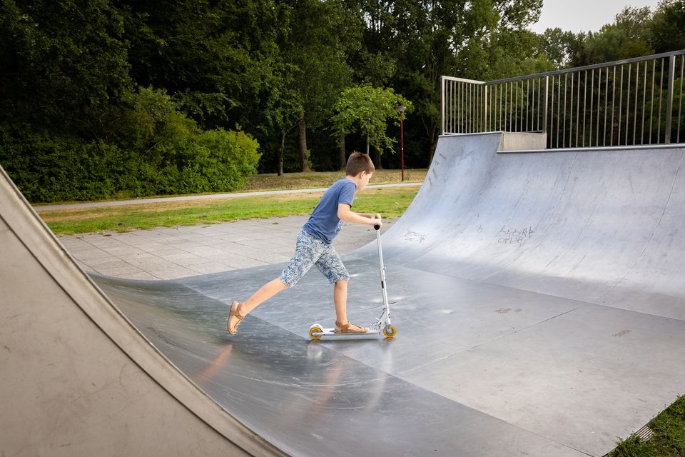 Jongen speelt met de step op de halfpipe in Park Oudegein