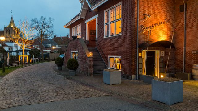 Avondopname van restaurant De Burgemeester in Linschoten, sfeervol verlicht Michelinster-restaurant in een karakteristiek pand aan een kronkelend straatje.