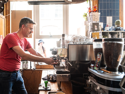 Eigenaar van Koffie en zo maakt een kopje koffie voor een klant