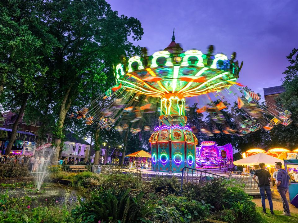 Mensen zwieren in een kermisattractie tijdens de avonduren