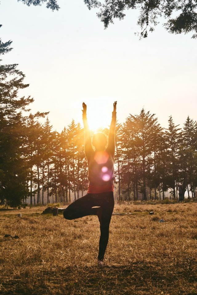 Een vrouw doet een yoga-oefening midden in de natuur.