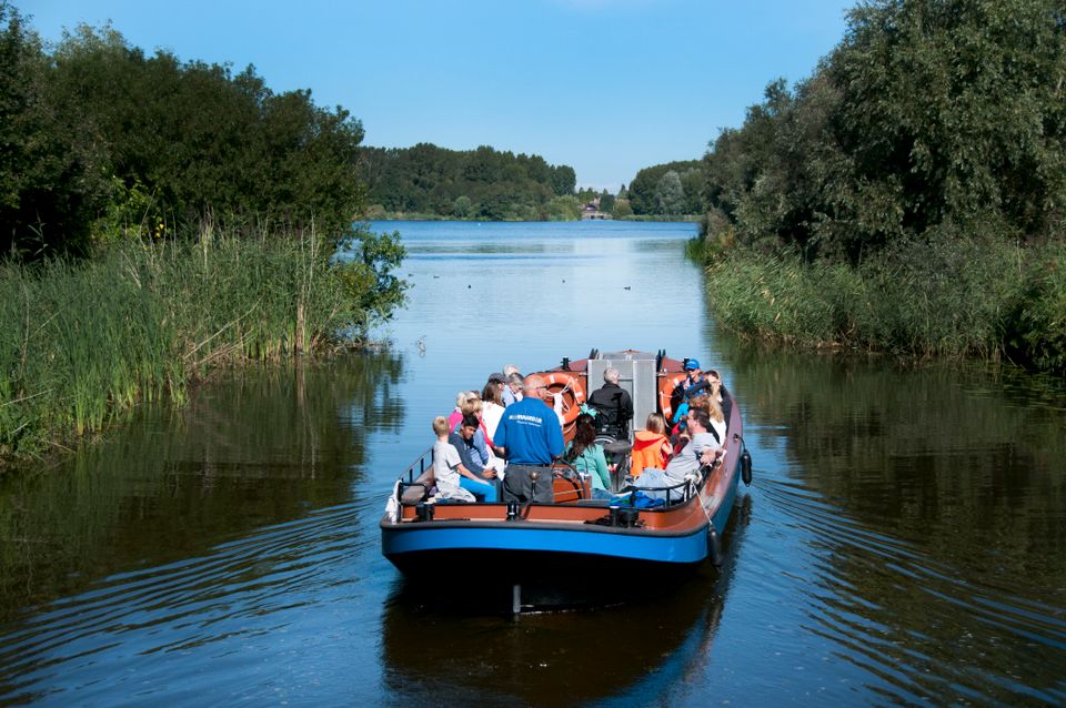 Foto van de Meervaarder in het water met mensen aan boort.