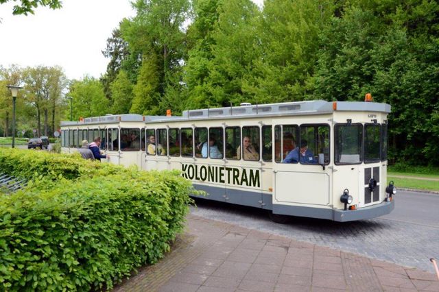 Mensen stappen in de kolonietram bij Museum de Proefkolonie.