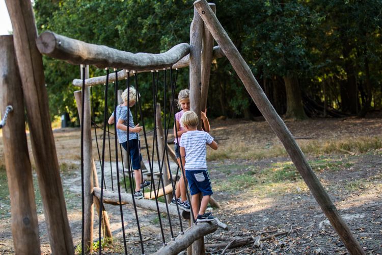 Kinderen klimmen op een klimtoestel in het Mastbos