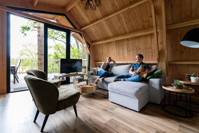 Camping Torentjeshoek binnenkant, stel zit op de bank.