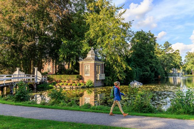 Een vrouw loopt langs de gracht voor Slot Zeist