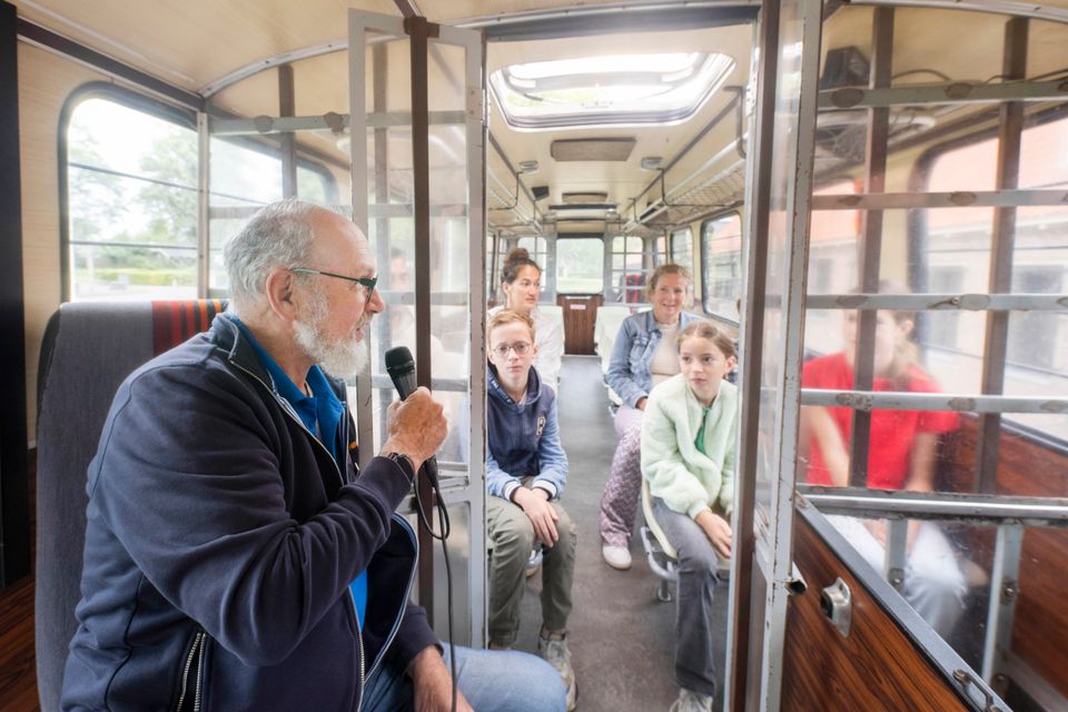 Kinderen met gids in de Boevenbus Veenhuizen