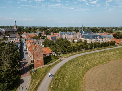 Luchtfoto Megen met de gevangentoren, St. Antonius van Padua en fietsers