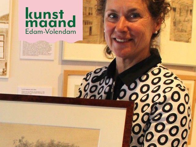 Een vrouw die een schilderij vasthoudt