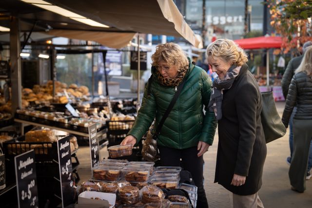 Zwei Frauen beim Kuchenkauf auf dem Markt