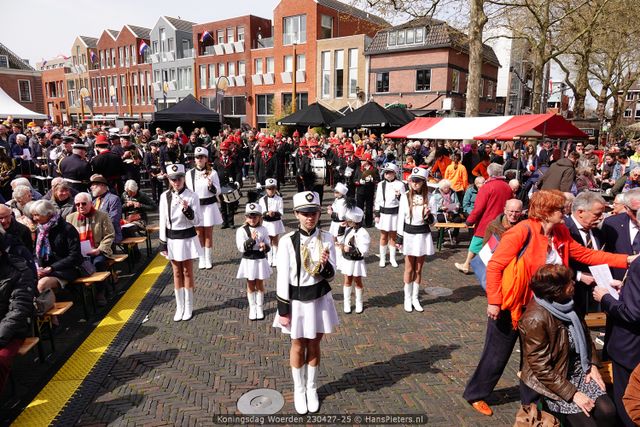 Evenement Koningsdag Woerden, Kerkplein, Groene Hart, majorettes en fanfare tijdens feestelijke viering met publiek en oranje accenten op het plein.