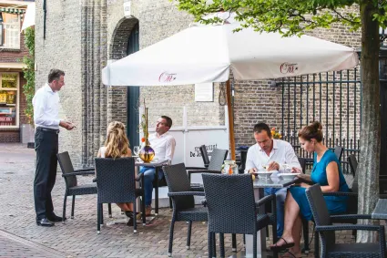 Twee koppels aan twee tafels op het terras bij Restaurant de Jouster Toer in Joure.
