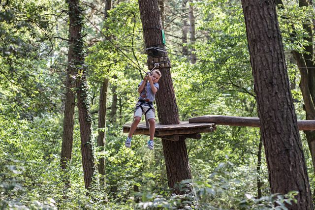 Jongetje gaat met zipline naar beneden in het klimpark