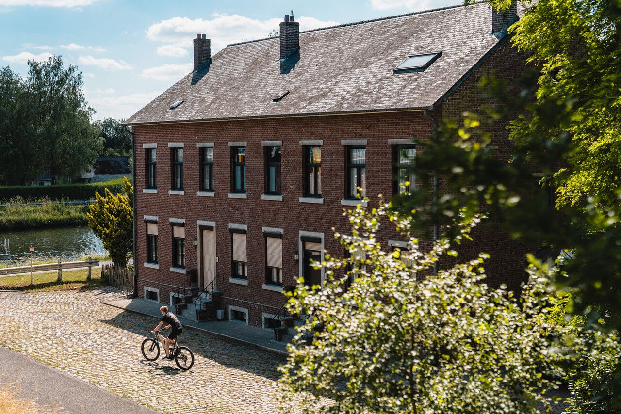 Een fietser fietst voorbij de douanierswoning