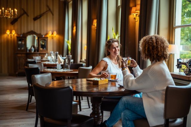 Twee vrouwen drinken een kop thee in een restaurant.