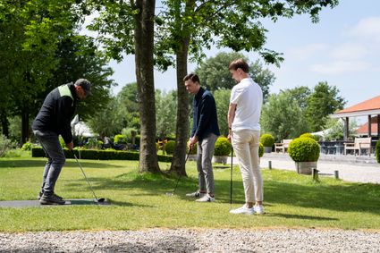 Golfbaan Pitch&Putt Buitenplaats Kameryck, Kamerik, Groene Hart, drie mannen spelen pitch en putt golf op een groene baan naast het terras en bomen, geschikt voor groepsactiviteit, teamuitje of bedrijfsuitje in het buitengebied.