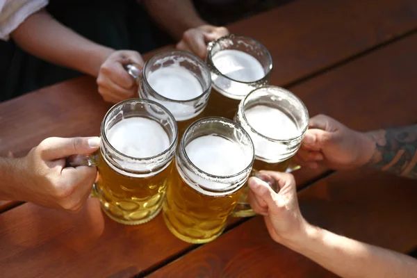 A group of of people cheering their beer on a table