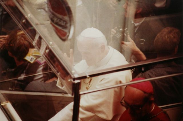 Een close-up van de paus in zijn pausmobiel. 