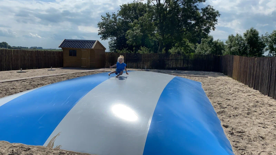 Spelend meisje op lucht trampoline