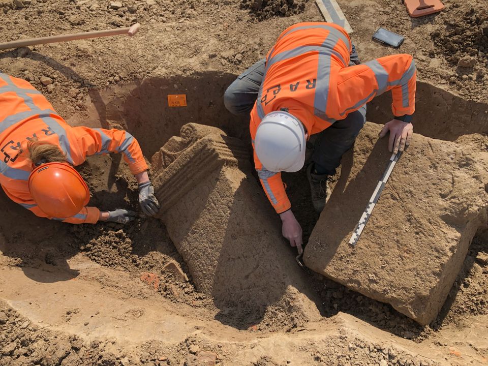 Archeologen leggen enkele altaarstenen vrij tijdens de opgraving.