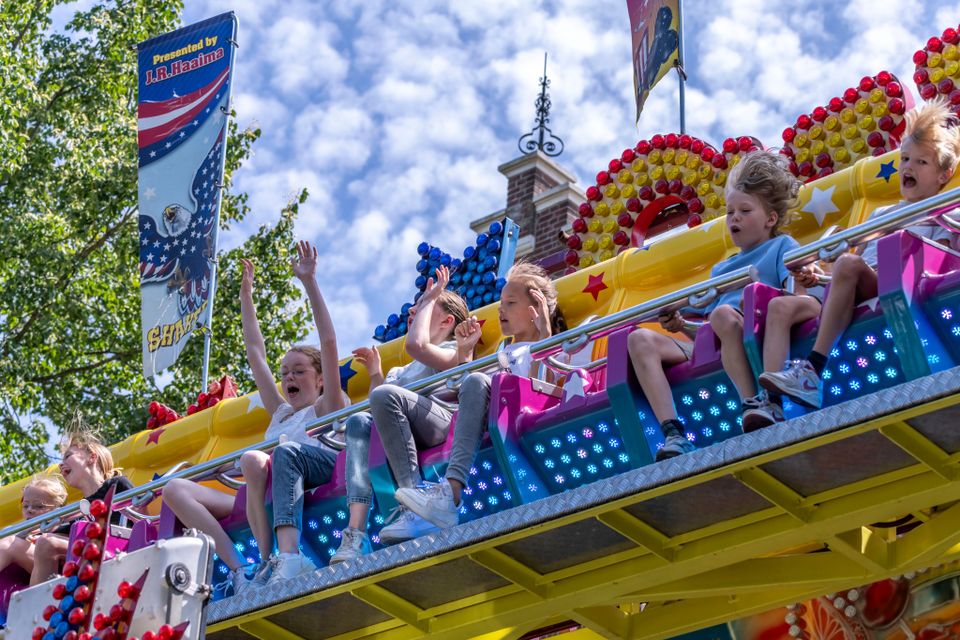Kinderen vermaken zich in een attractie op de kermis in Oisterwijk