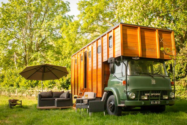 Op de foto staat het bedford te zien met de Tiny house buiten staat een lounge set