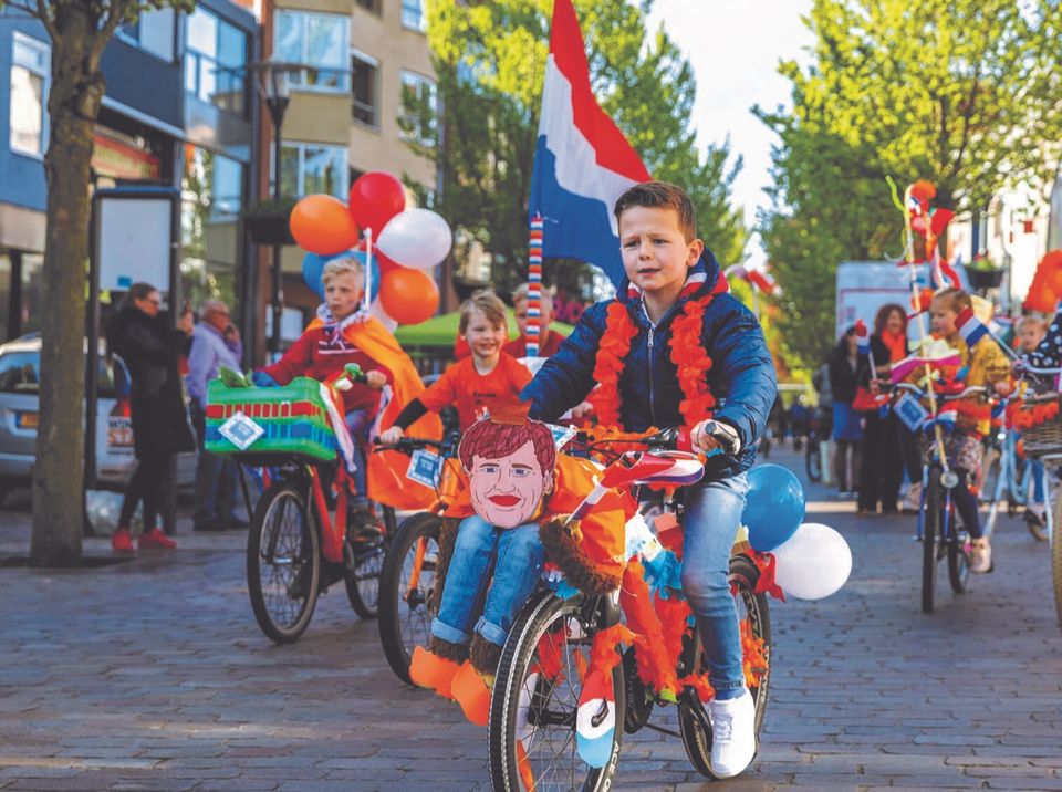 Fietsende jongen tijdens koningsdag