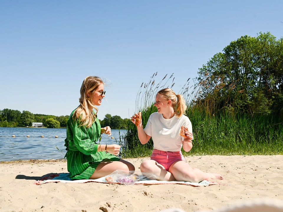 Twee meiden die genieten van het strand bij de Delftse Hout