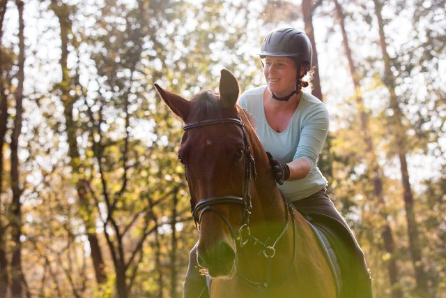 Foto van een ruiter op paard gefotografeerd van dichtbij.