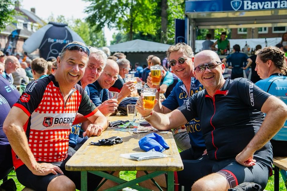 Een groepje renners geniet van Brabantse gezelligheid op De Lind met een biertje
