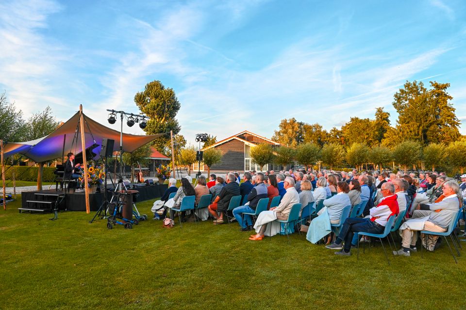 Publiek geniet van een sfeervolle buitenvoorstelling tijdens het Midzomer Theater bij Buitenplaats Kameryck in Kamerik met podium, verlichting en zomerse setting