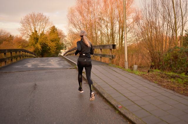 Hardloper die over een brug in het Amsterdamse Bos rent.