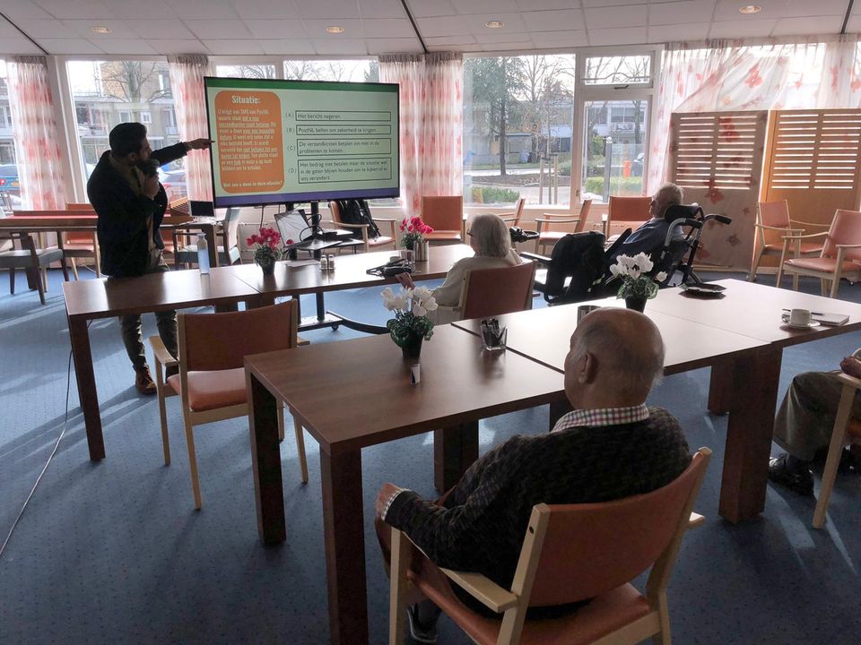 Een bijeenkomst voor senioren waar IT wordt uitgelegd.