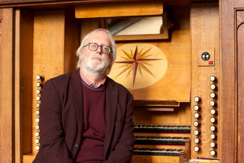 Een man die voor een orgel zit in de kerk