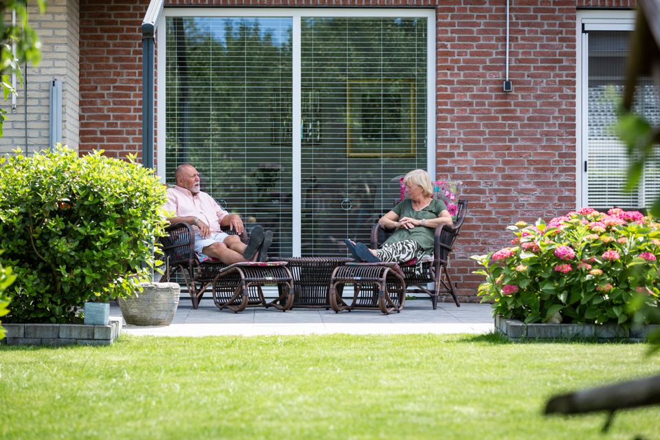 Een echtpaar zit op het terras in hun tuin van de woning in Lelystad, Flevoland